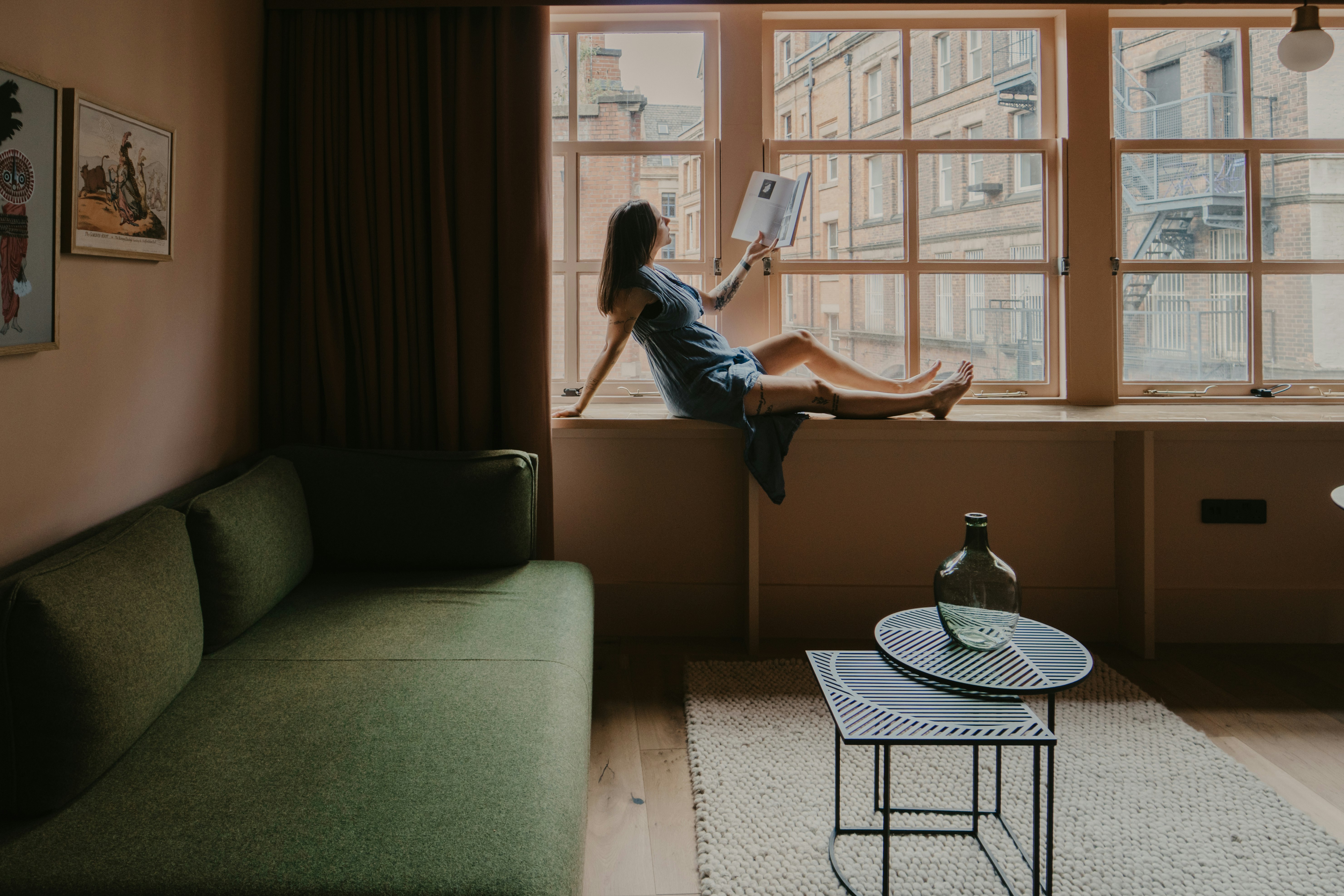 woman in blue denim jeans sitting on gray couch